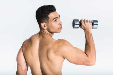 Fototapeta na wymiar handsome mixed race man with muscular torso holding dumbbell on white