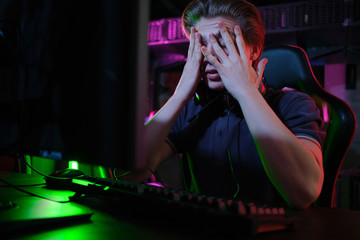 Professional young caucasian gamer playing online on his PC. He upset because of losing the game © nazarovsergey