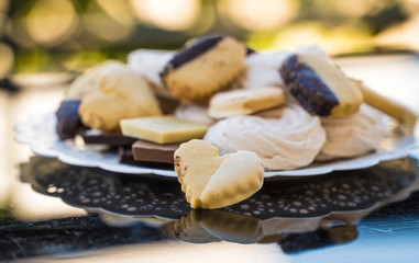 marshmallows, biscuits and chocolate in a white plate on a background
