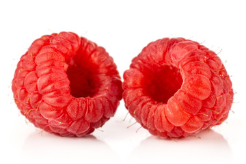 Closeup of two whole fresh red raspberry isolated on white background