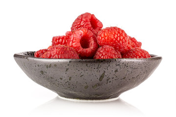 Lot of whole fresh red raspberry on grey ceramic plate isolated on white background