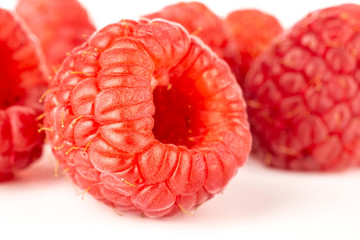 Lot of whole fresh red raspberry isolated on white background