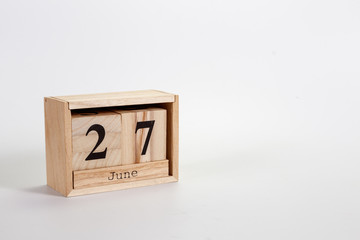 Wooden calendar June 27 on a white background