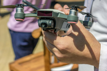 Fototapeta premium The Man is Holding Small Smart Drone in Hand. use of the drone on a walk. Drone operator. Drone flying