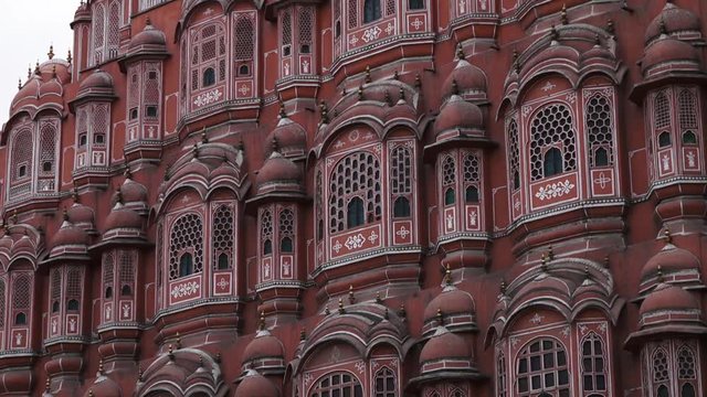 Tilt up along the front of the Hawa Mahal palace showing the numerous latticed windows and red sandstone
