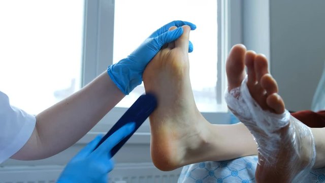 Girl removes keratinized skin layer from the feet - pedicure in the home office