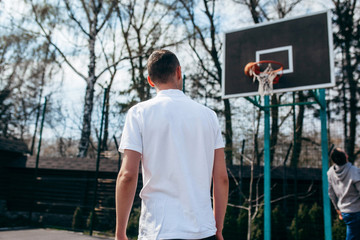 Young man wearing white blank polo, playing streetball