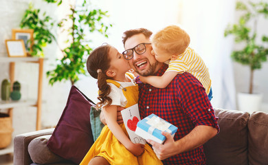 Happy father's day! Children congratulates dad and gives him gift and postcard .