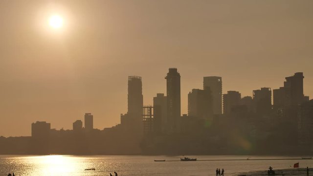 Sunset on the background of Mumbai skyscrapers. View from Chowpatty Beach.