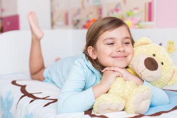 Obraz na płótnie Canvas Cheerful little cute adorable baby girl playing with yellow teddy bear in her children room. Childhood, leisure kid time, happiness concept