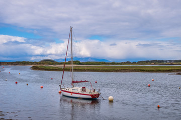 Irvine Harbour in Ayrshire Scotland looking Over a Single Masted Sailing Boat to the Arran Hills in the hazy Distance.