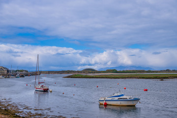 Fototapeta na wymiar Irvine Harbour in Ayrshire Scotland looking Over a Single Masted Sailing Boat to the Arran Hills in the hazy Distance.