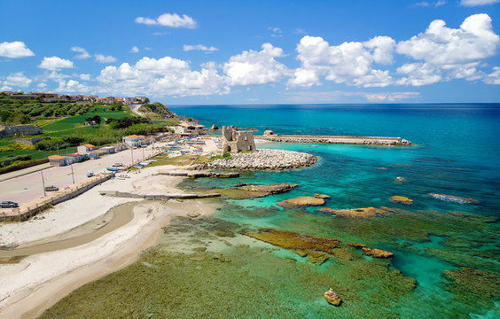 Fishing italian village Briatico in Calabria with turquoise sea and old saracen tower. Drone Panorama - Italy