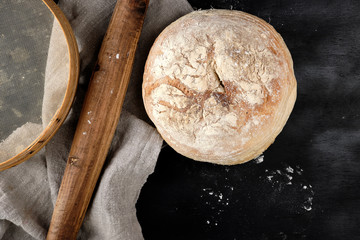 round baked bread and wooden old rolling pin