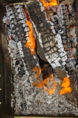 Firewood, logs burn in the grill on the street. Brazier view from the top, high heat from burning wood. Picnic, firewood, coal, heat in macro