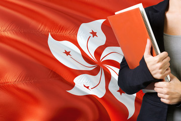 Learning language concept. Young woman standing with the Hong Kong flag in the background. Teacher...