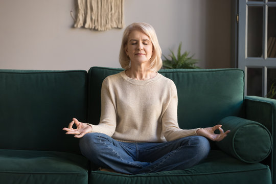 Grey haired mature woman meditating, practicing yoga at home Stock-Foto |  Adobe Stock