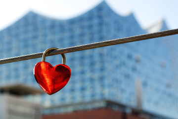 Red heart-shaped lock with the Elbphilharmonie in Hamburg in the background