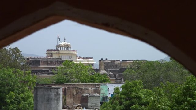 View looking through an arch at the Chandra Mahal rising above the other buildings at City Palace in Jaipur, India