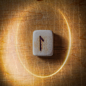 Laguz. Handmade scandinavian wooden runes on a wooden vintage background in a circle of light. Concept of fortune telling and prediction of the future.