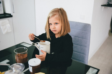 beautiful and sweet girl cooks cocoa at the table