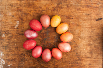 Easter eggs on a wooden background. Happy easter. Bright multicolored shiny easter eggs. Copyspace. Multicolored eggs are lying in circle. Place for text