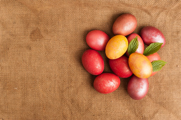Easter eggs on a wooden background. Happy easter. Bright multicolored shiny easter eggs are on burlap. Copyspace. Place for text