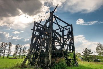 remains of old burnt windmill in the field before the rain