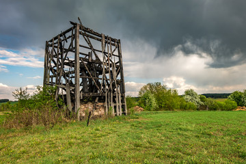 remains of old burnt windmill in the field before the rain