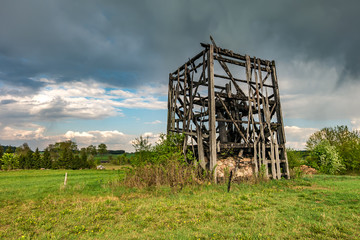 remains of old burnt windmill in the field before the rain