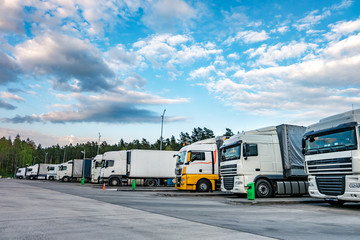 Trucks in a row with containers in the parking lot near forest , Logistic and Transport concept