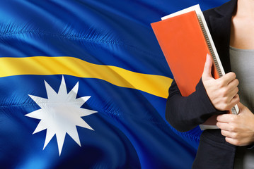 Learning Nauruan language concept. Young woman standing with the Nauru flag in the background....