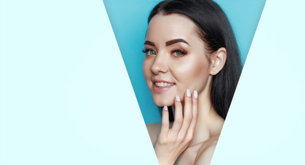 Beautiful young woman with perfect glow smooth clean skin touching her face. Portrait of model with...