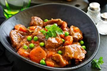 Beef stew in Burgundy. With carrots, onions, peas and champignons in wine. View from above.