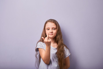 Fun pupil casual girl with long hair style looking serious and showing fuck off sign by finger on...