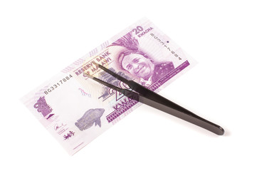 Banknote and tweezers isolated on the white background