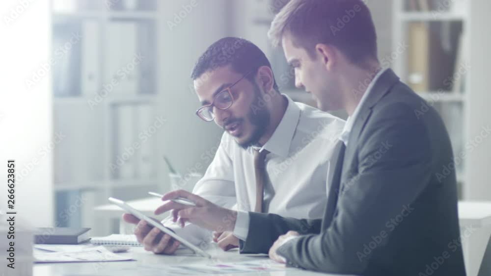 Aufkleber tracking shot of middle eastern businessman smiling and discussing something on screen of digital ta
