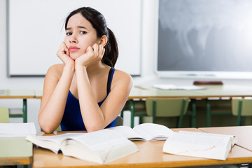 Girl is pondering about complicated task at the desk