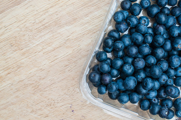 Blueberries in plastic container, copy space for text. Fresh organic blueberry