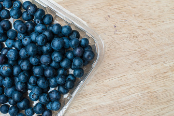 Blueberries in plastic container, copy space for text. Fresh organic blueberry