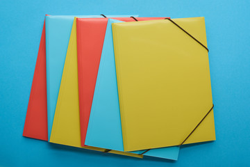 top view of arranged red, blue and yellow paper binders
