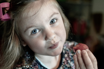 Girl in curlers eating strawberries