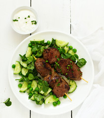 Beef kebab with cucumber and green pea salad. Healthy food.