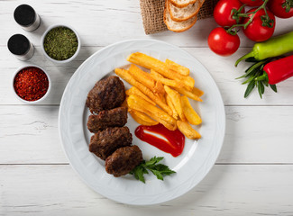 Grilled meatballs  and french fries with vegetables