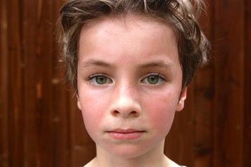 Portrait of a hot and sweaty child with big green eyes and short brown hair