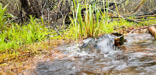 Water from the ground from a rusty pipe. Natural water from the earth.