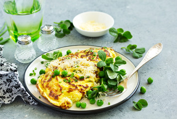 Breakfast. Frittata Italian omelet with green peas and salad.