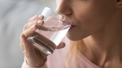 Close up image woman holds glass drinking still water