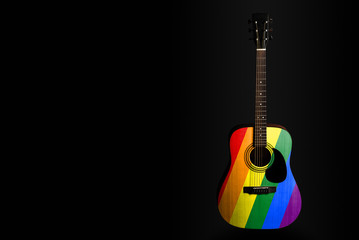 Obraz na płótnie Canvas Acoustic concert guitar with a drawn flag rainbow, on a dark background, as a symbol of national creativity or folk song.