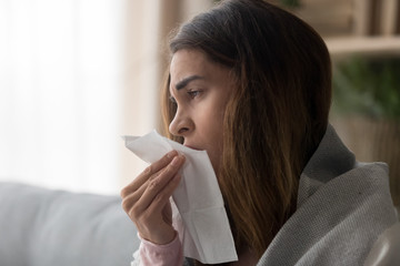 Side view close up woman holding paper tissue sneezing